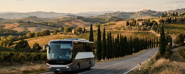 An intercity coach driving through the Tuscan countryside between Florence and Siena on a road bordered by cypress trees and vineyards.